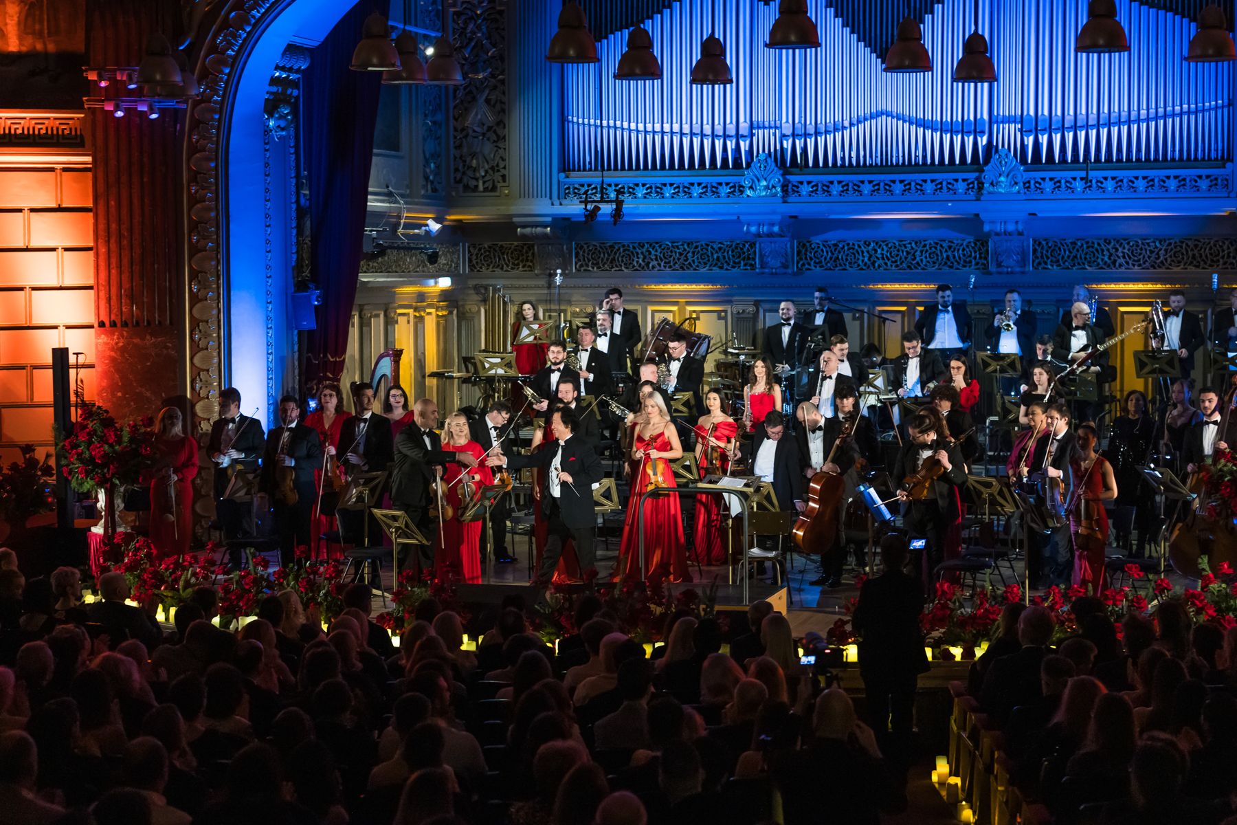 Orchestra Simfonică București în picioare, la aplauze, pe scena Ateneului Român, sub orgă