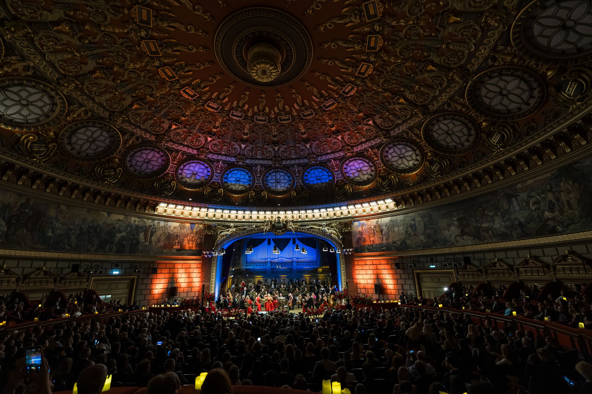 Sala Ateneului Român văzută din spate, cu cupola pictată și Orchestra Simfonică București pe scenă